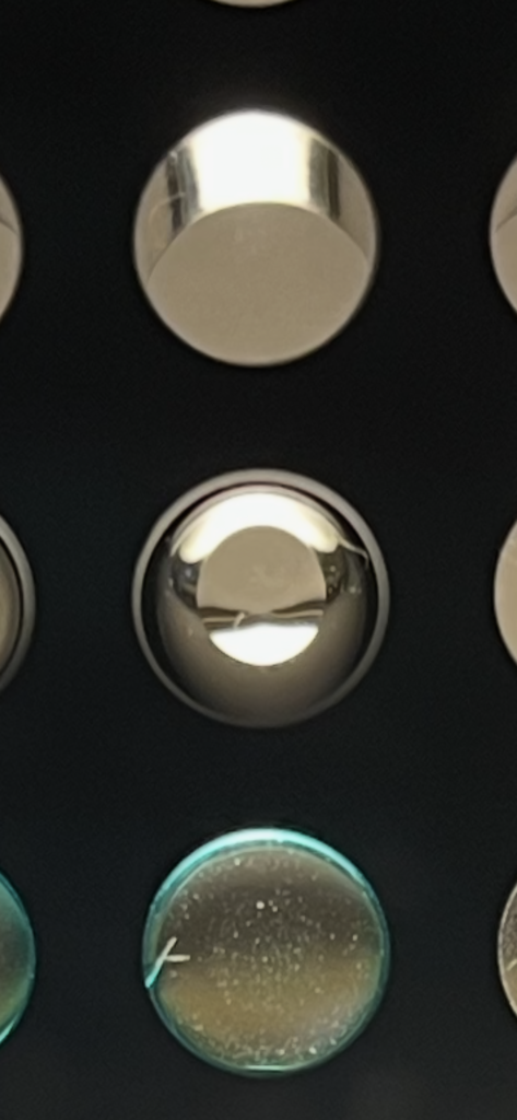 96 well reservoirs with no soln on top, 100 ul of PBS showing a meniscus and in the bottom well cured Opti-Well.